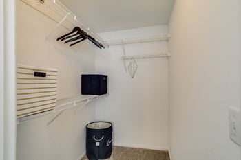 A small closet with a tv and a black trash bag